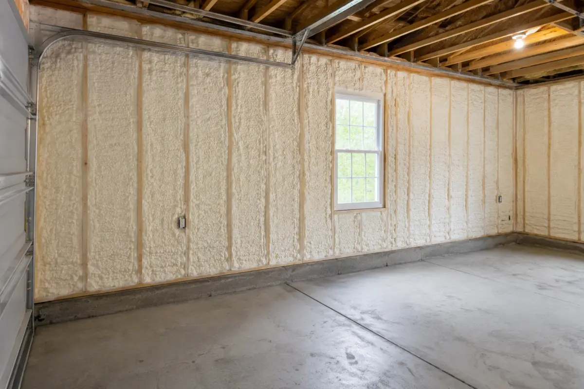 Finished garage wall cavities insulated with spray foam